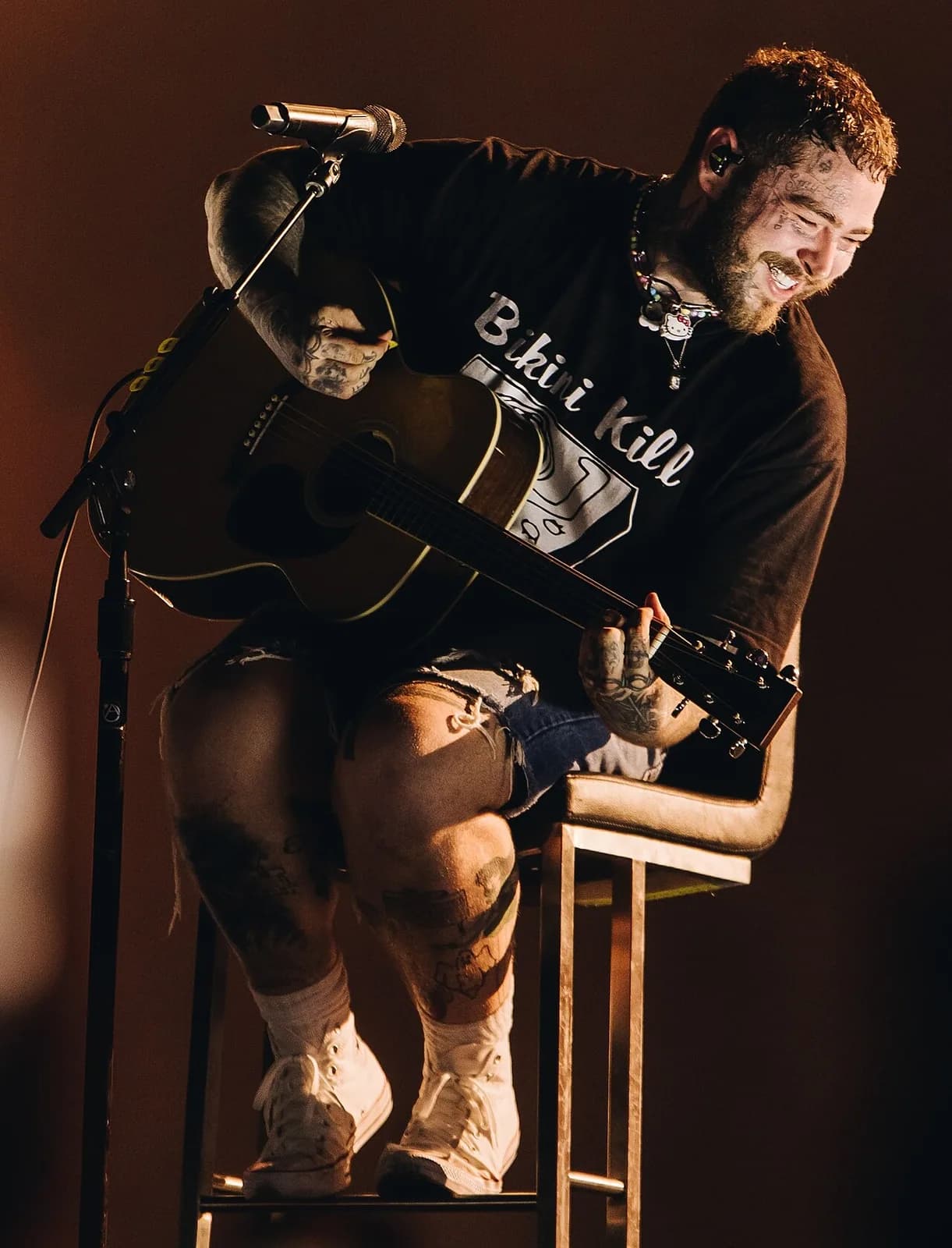 Post Malone en concert avec une guitare acoustique